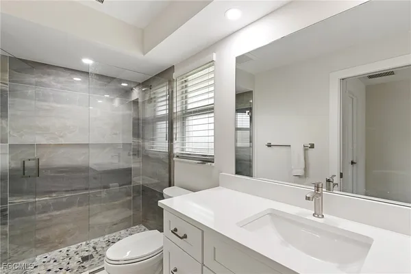 a bathroom with a sink a toilet and shower