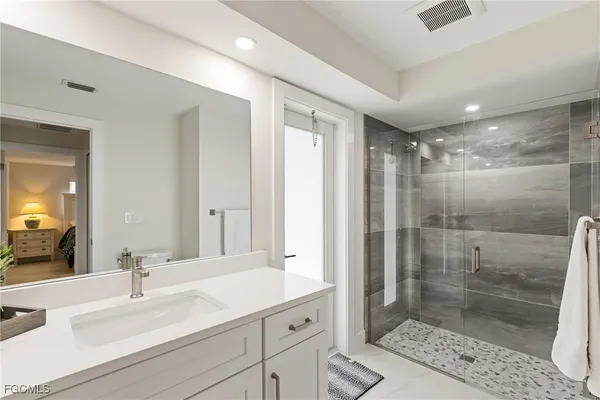 a bathroom with double vanity and a shower