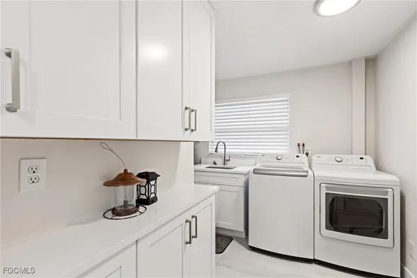 a utility room with sink dryer and washer