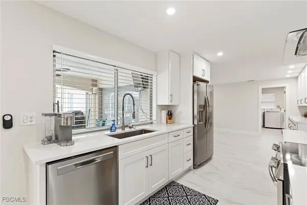 a kitchen with stainless steel appliances a sink stove and cabinets