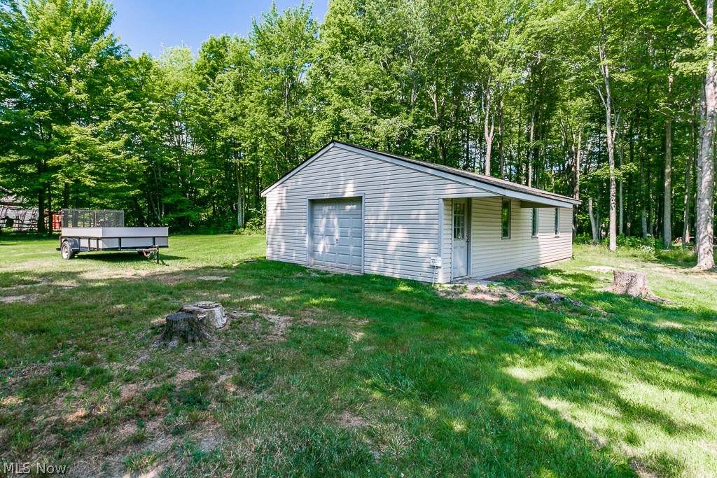 7710 Brakeman Road Painesville, OH 44077 - Photo 32 of 34 View of outbuilding featuring a garage and a lawn
