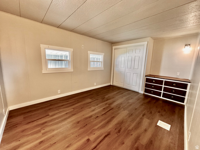 158 Cushing Way Layton, UT 84041 - Photo 7 of 14 Spacious room featuring wood-finish flooring, light-toned walls, and white trim
