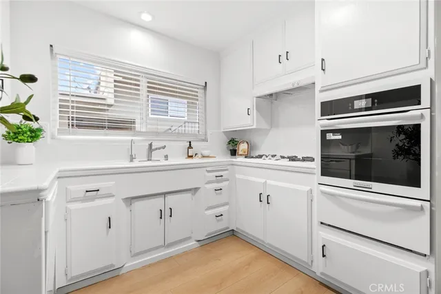 a kitchen with granite countertop white cabinets and white appliances
