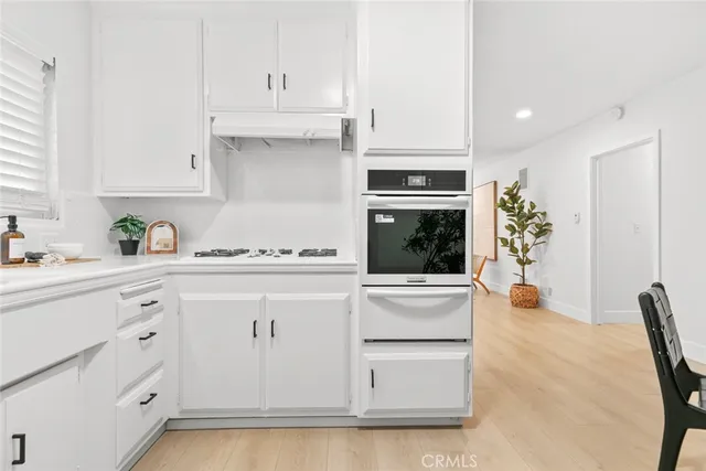 a kitchen with white cabinets and appliances