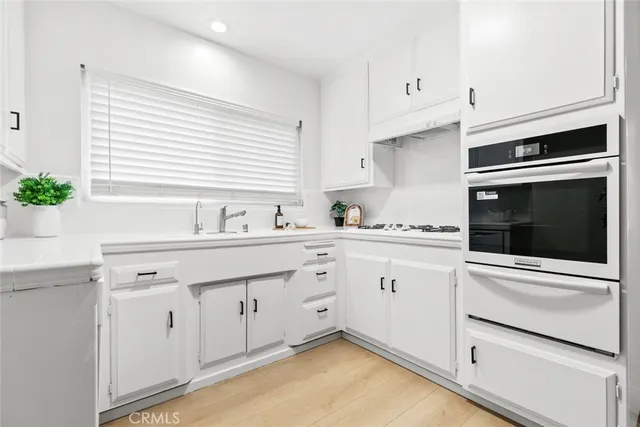 a kitchen with granite countertop white cabinets and white appliances
