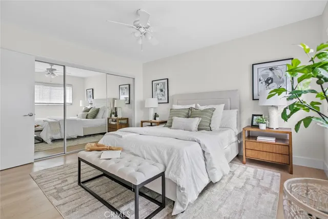 a spacious bedroom with a bed a couch and a potted plant