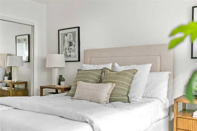 a bedroom with a bed and a lamp on dresser