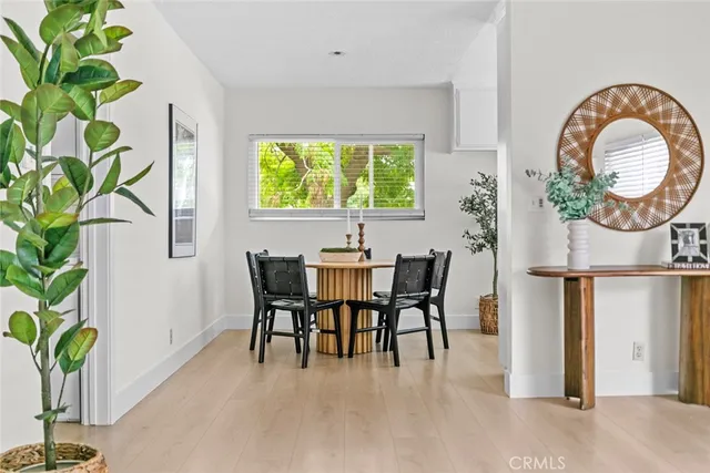 a dining room with furniture potted plants and wooden floor
