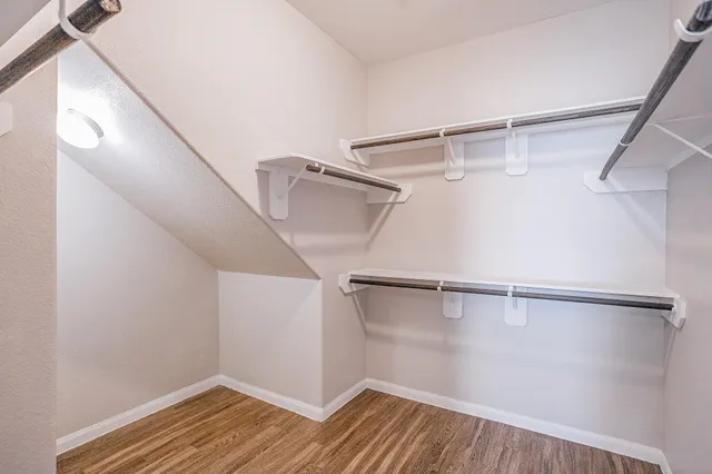 a view of a room with wooden floor and white walls