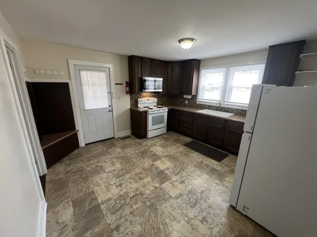 a large kitchen with a refrigerator a sink dishwasher a stove top oven a refrigerator and dishwasher