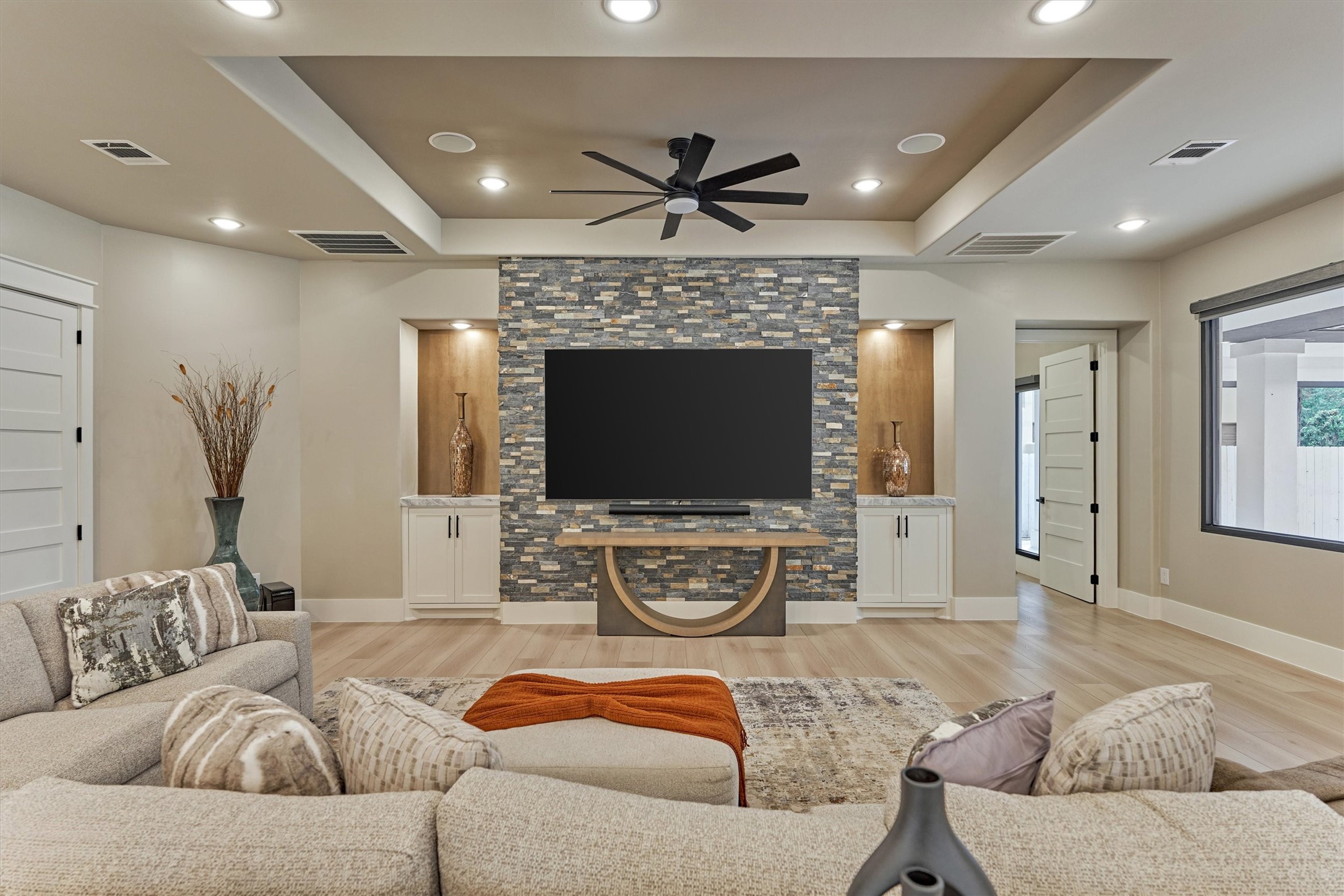 1907 Woerner Road Houston, TX 77090 - Photo 11 of 50 Grand family room with stacked stone accent wall, recess ceiling, art niches and built-ins. The door to the left leads to one of two private guest quarters.