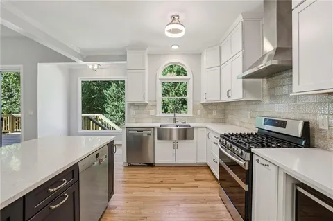 a kitchen with a stove a sink and a window