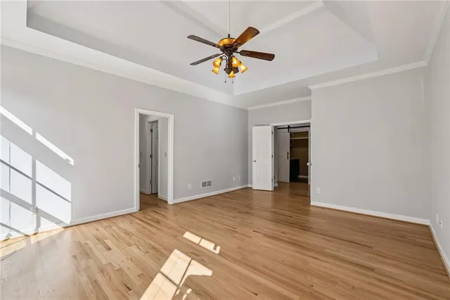 a view of an empty room with window and wooden floor