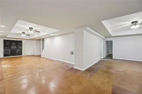 a view of an empty room with a chandelier fan