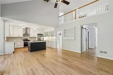 a large kitchen with cabinets wooden floor and stainless steel appliances