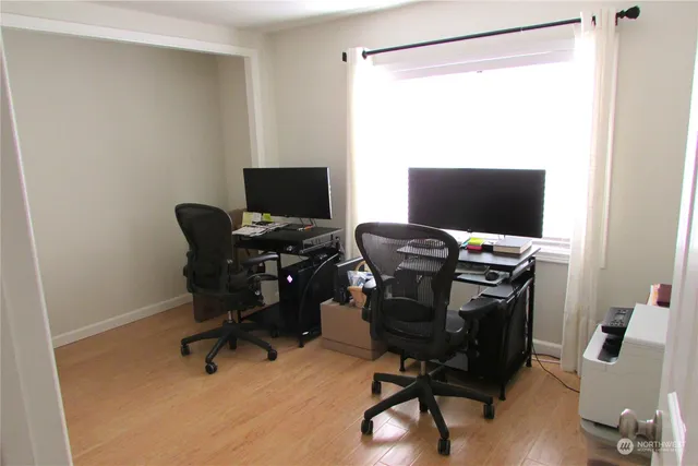 a view of a workspace with furniture and a window