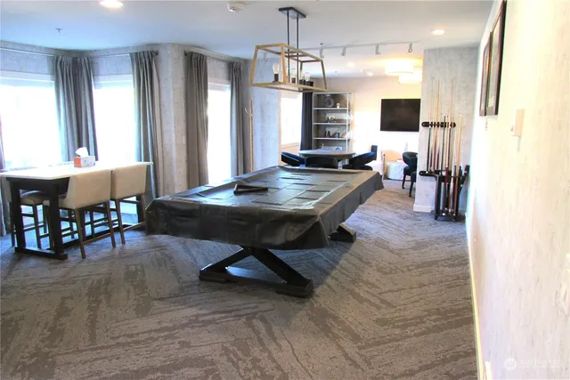 a room with pool table and windows