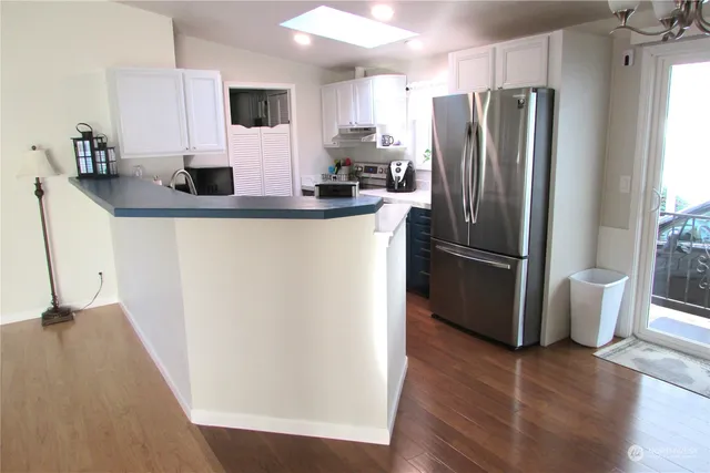 a kitchen with stainless steel appliances a refrigerator microwave and sink