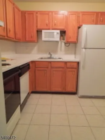 a kitchen with granite countertop a sink a stove and a refrigerator