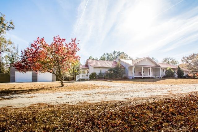 a front view of a house with a yard and covered with snow