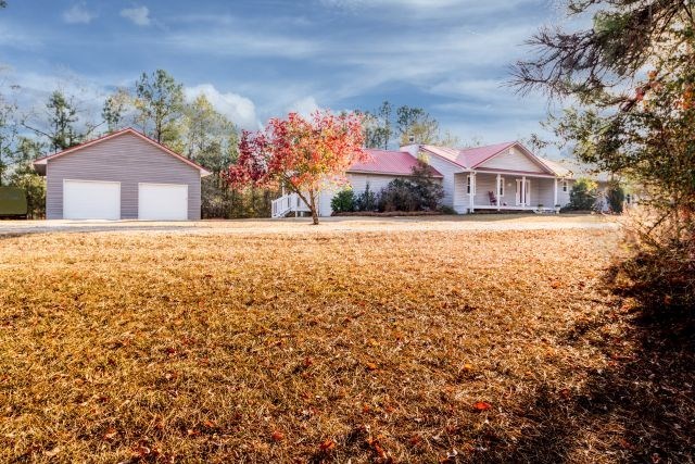 1630 Johnson Road Musella, GA 31066 - Photo 24 of 28 a front view of house with yard and trees in the background