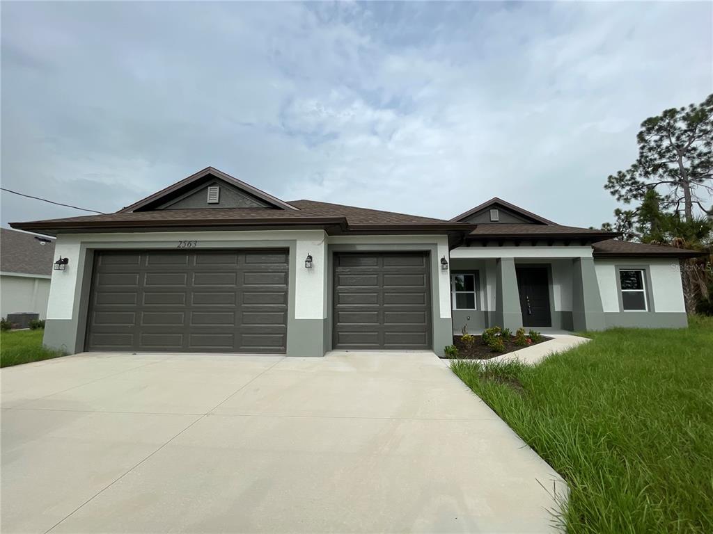 2563 Longworthy Road North Port, FL 34288 - Photo 1 of 7 a front view of a house with a yard and garage