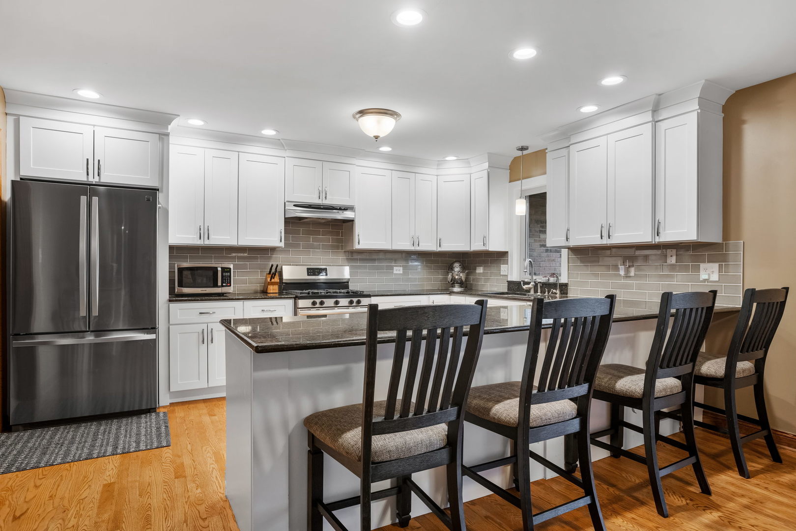 2050 South Spencer Road New Lenox, IL 60451 - Photo 19 of 33 a kitchen with stainless steel appliances granite countertop a dining table chairs refrigerator and sink