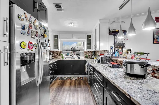 a kitchen with refrigerator and cabinets
