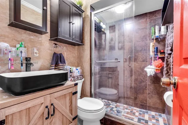 a bathroom with a sink a toilet and shower