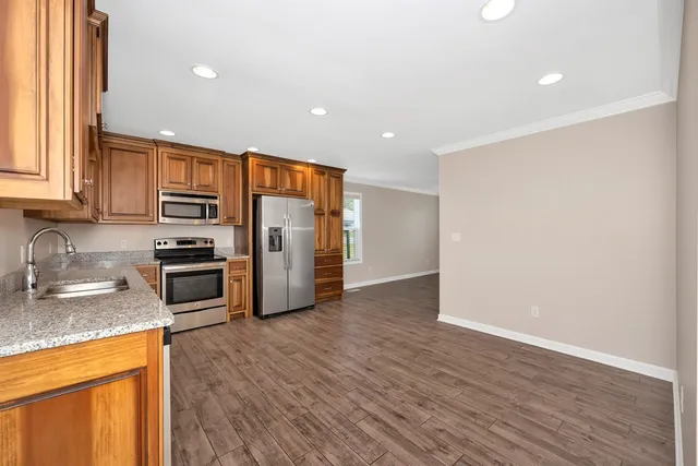 a kitchen with stainless steel appliances granite countertop a refrigerator microwave and sink