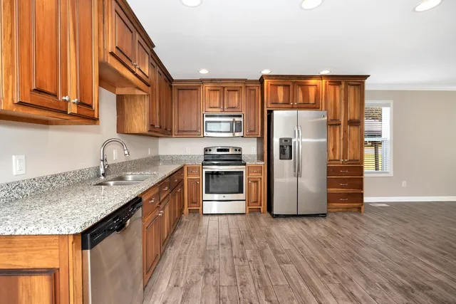 a kitchen with stainless steel appliances granite countertop a refrigerator and a sink