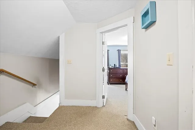 a view of a hallway with a livingroom and a bathroom with sink