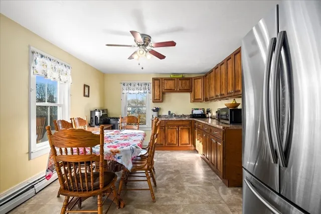 a kitchen with stainless steel appliances granite countertop a refrigerator a stove a kitchen island with a dining table and chairs