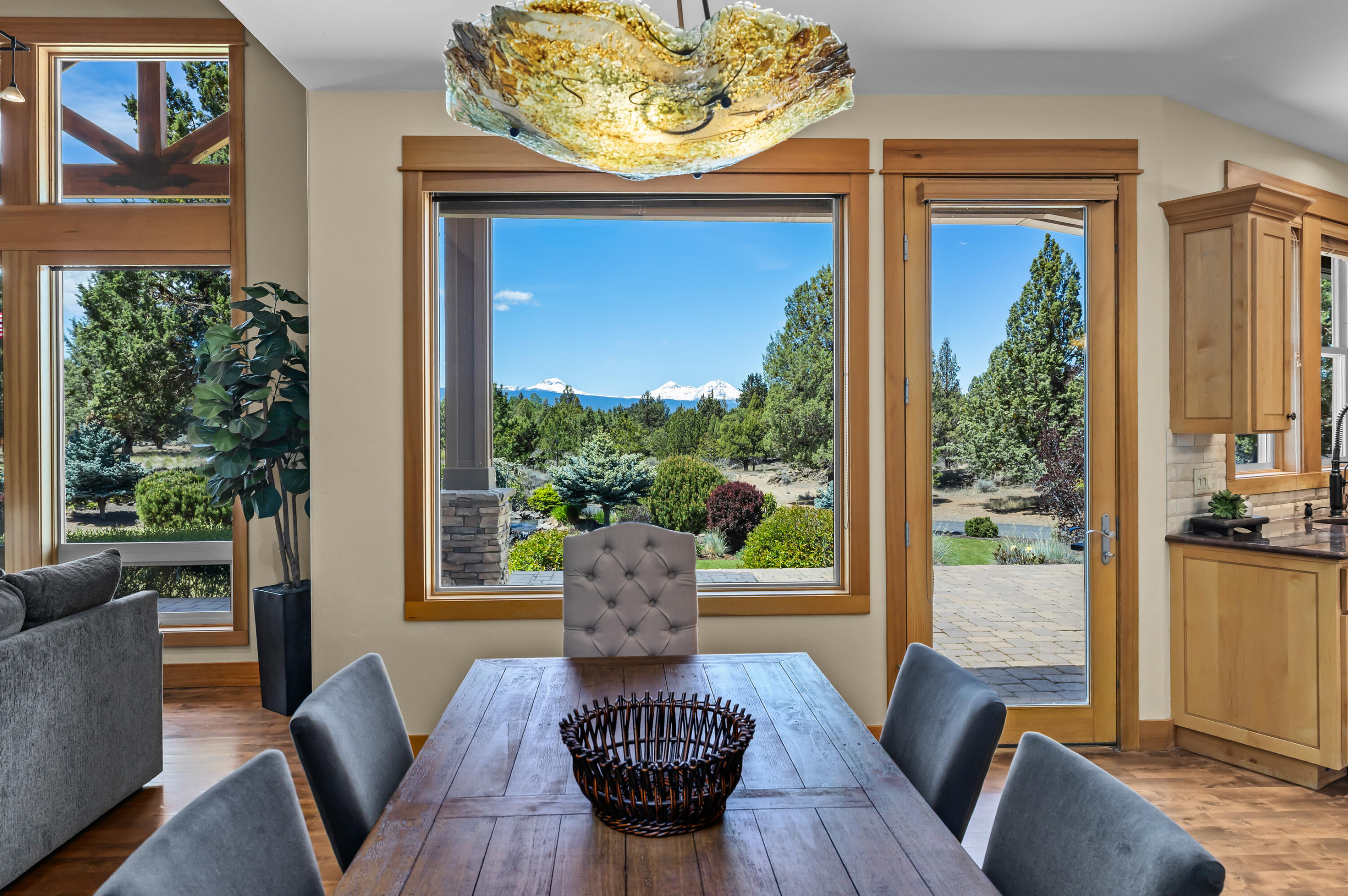 64145 Hunnell Road Bend, OR 97703 - Photo 13 of 65 Positioned between the great room and kitchen, the dining area enjoys warm wood flooring, natural light and a direct connection to the outdoor setting, creating an easy flow for everyday meals and entertaining.