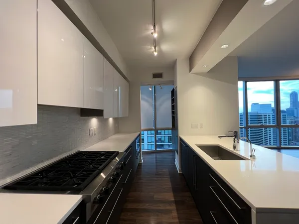 a kitchen with stainless steel appliances a sink stove and cabinets
