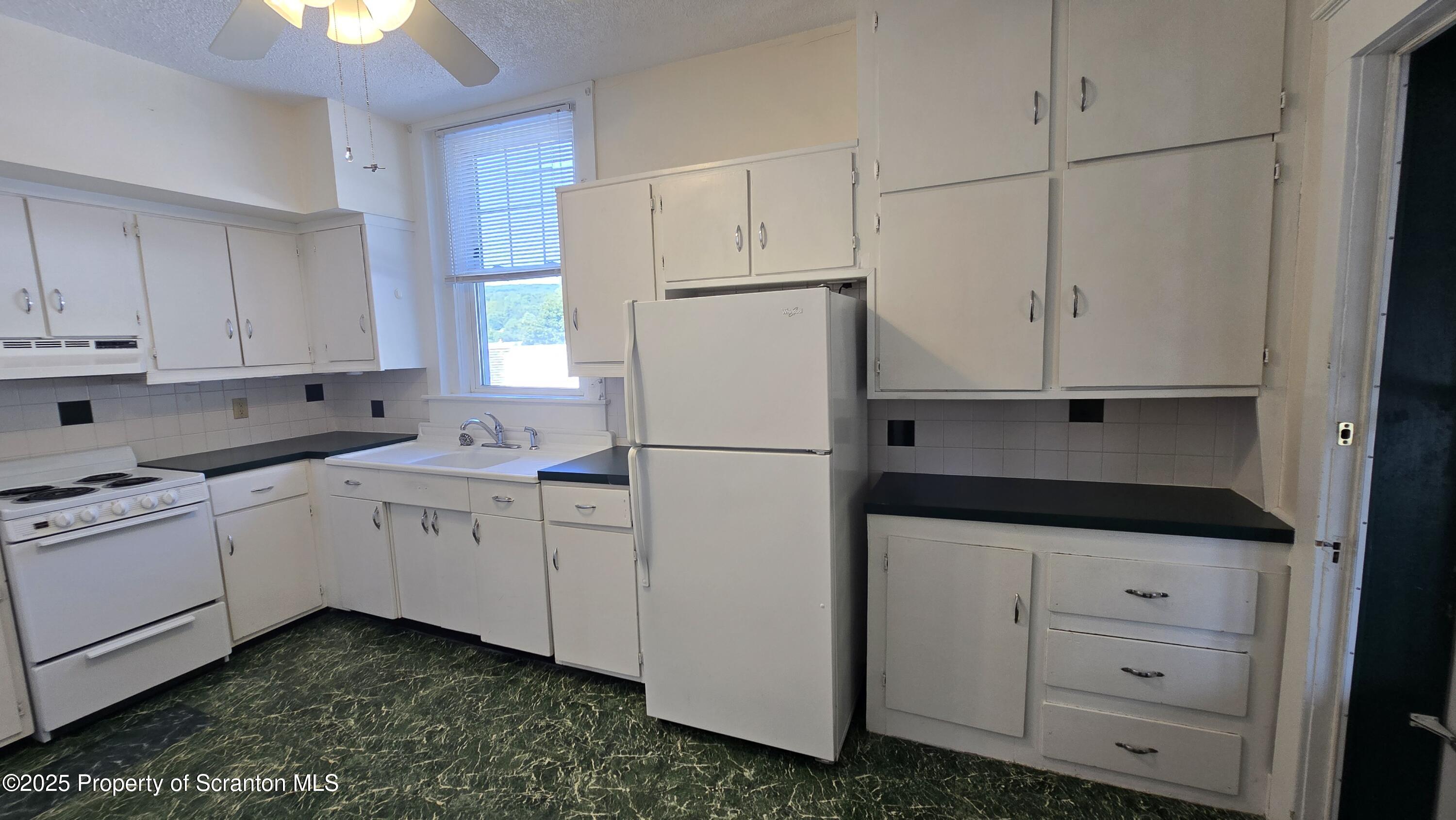 281 East Main Street, Unit 3 Plymouth, PA 18651 - Photo 3 of 9 a kitchen with white cabinets and white appliances