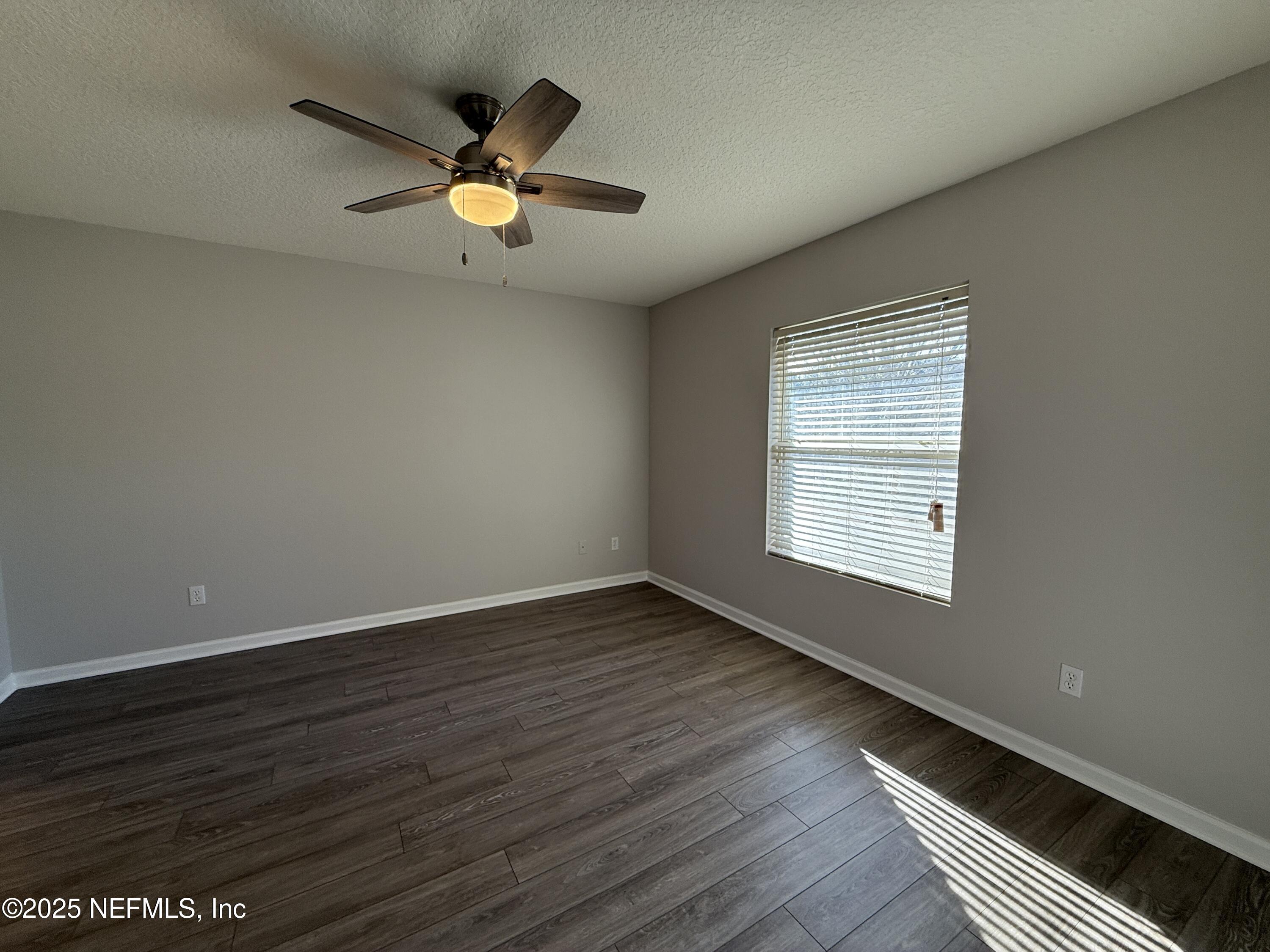 1865 Green Springs Circle, Unit C Fleming Island, FL 32003 - Photo 12 of 29 an empty room with wooden floor and windows