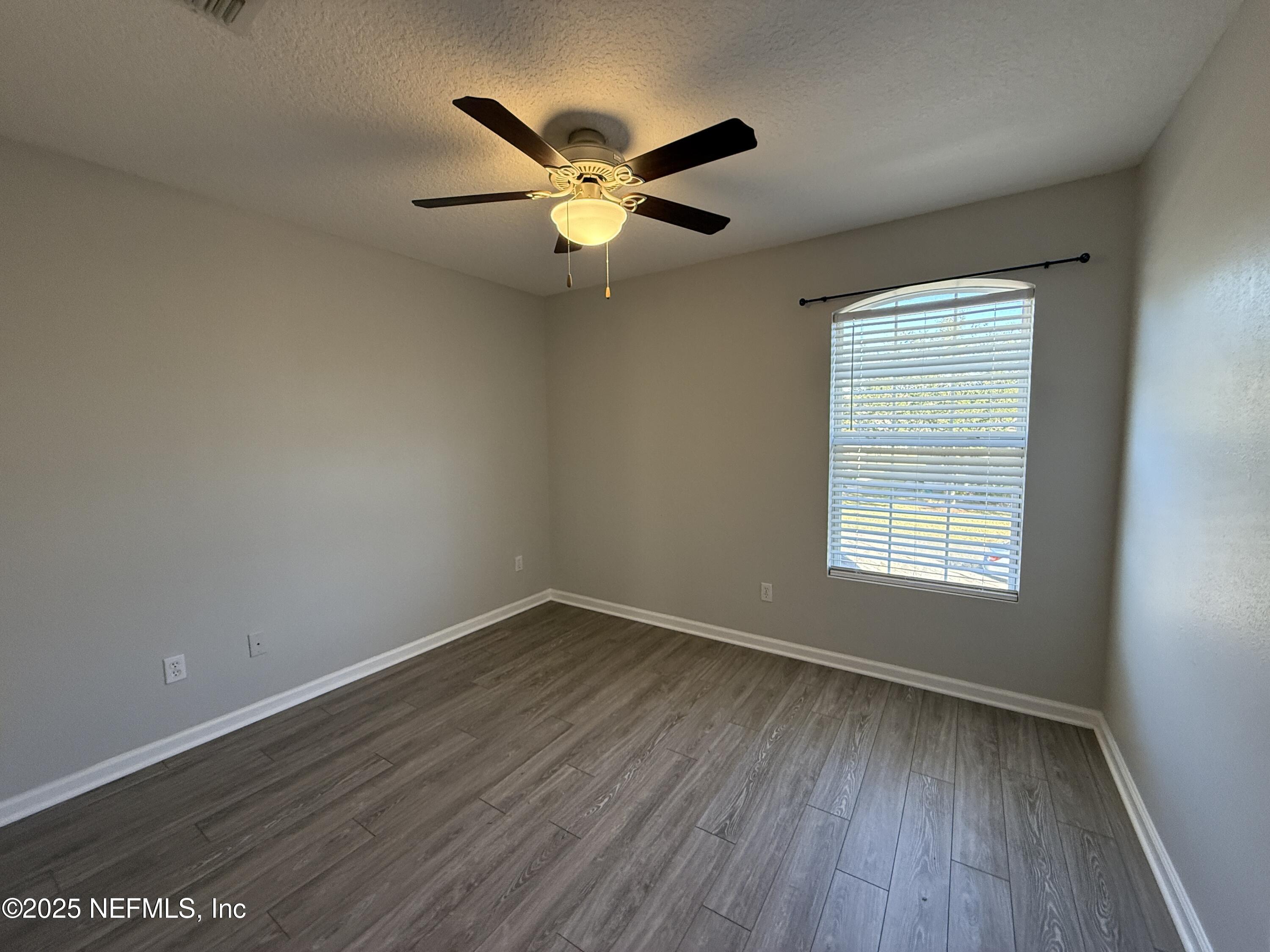 1865 Green Springs Circle, Unit C Fleming Island, FL 32003 - Photo 15 of 29 a view of an empty room with wooden floor and a window