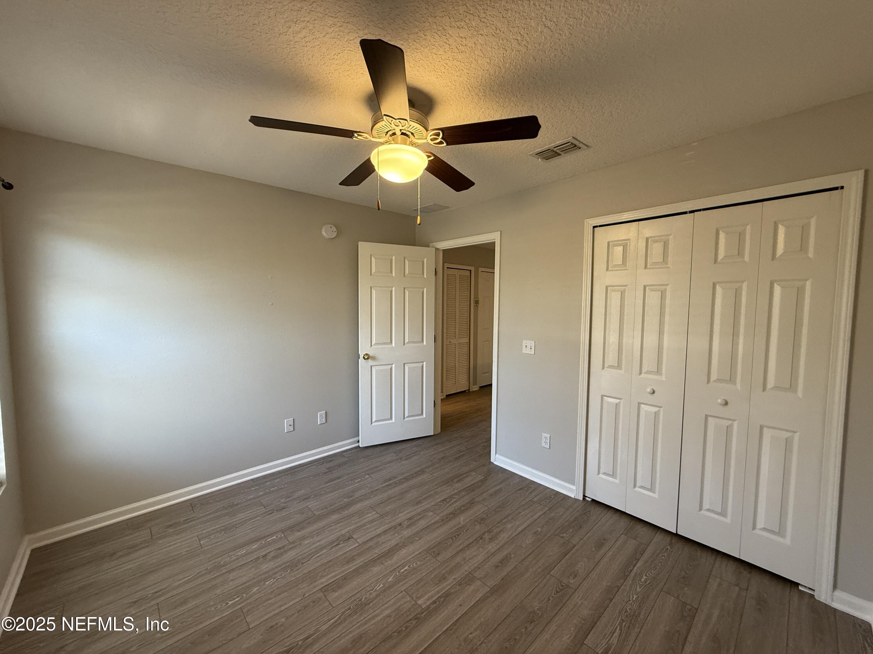 1865 Green Springs Circle, Unit C Fleming Island, FL 32003 - Photo 16 of 29 a view of an empty room with wooden floor
