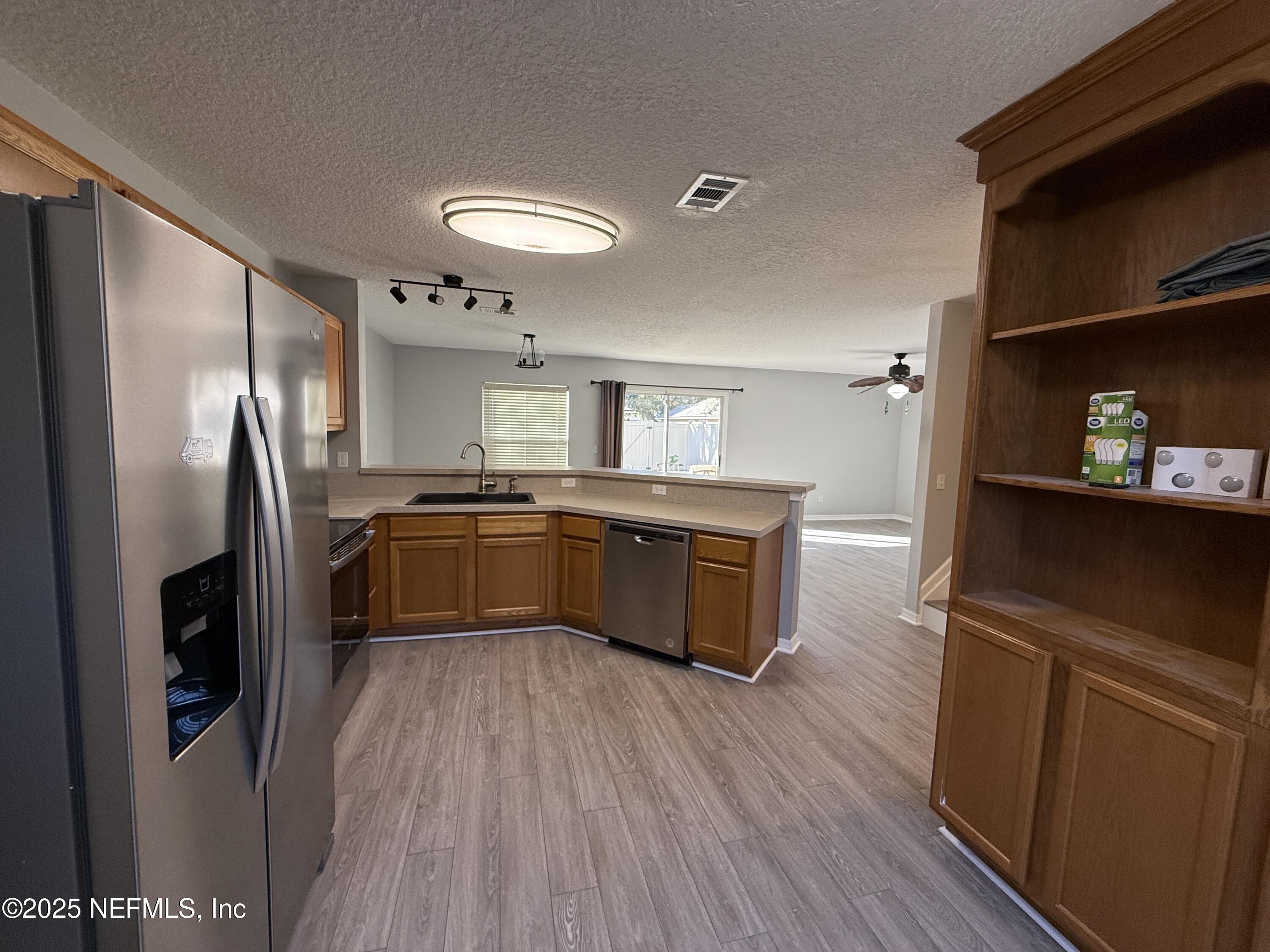 1865 Green Springs Circle, Unit C Fleming Island, FL 32003 - Photo 5 of 29 a kitchen with stainless steel appliances a sink a stove a refrigerator and cabinets