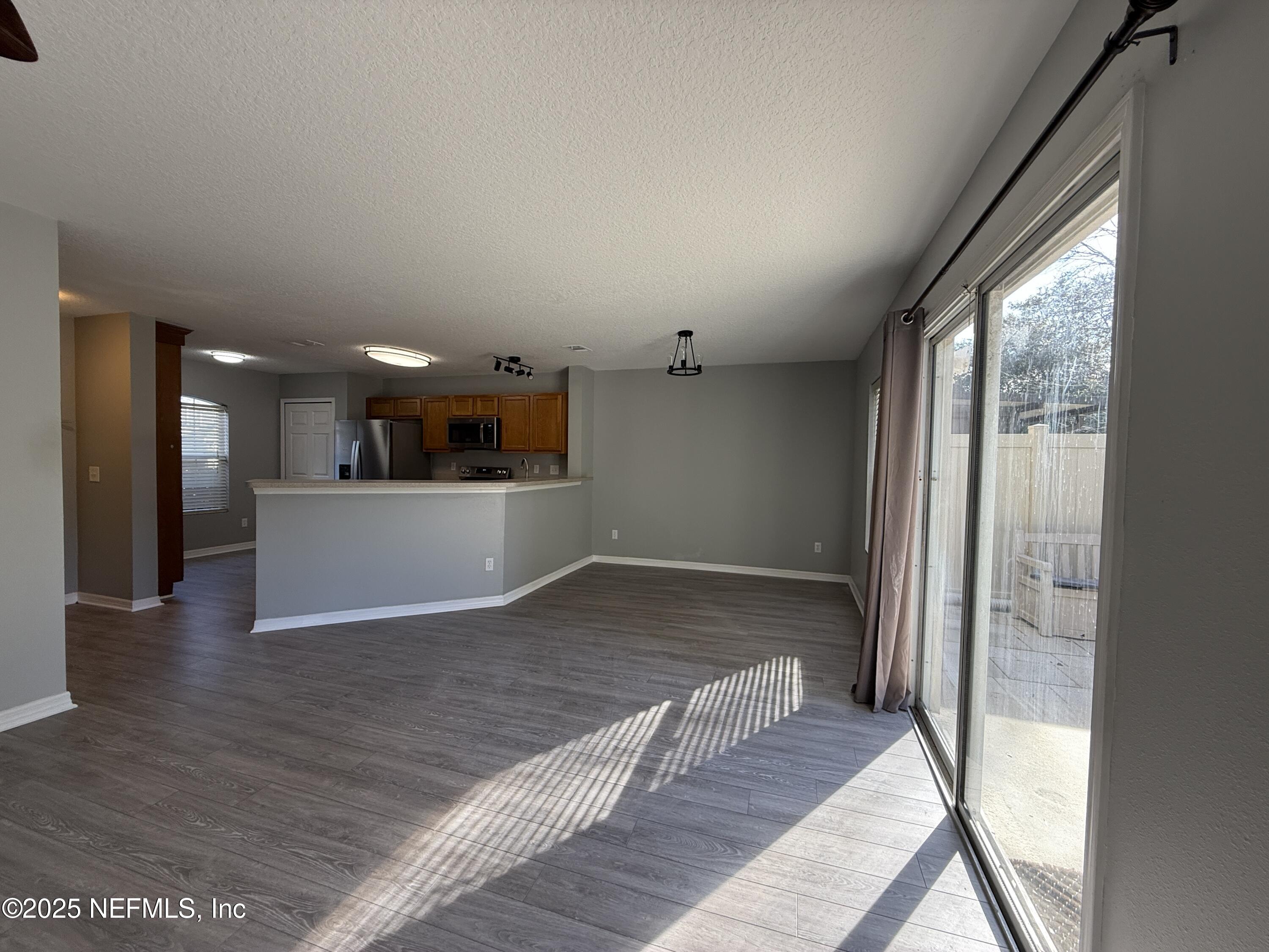 1865 Green Springs Circle, Unit C Fleming Island, FL 32003 - Photo 8 of 29 a view of a big room with wooden floor and a kitchen