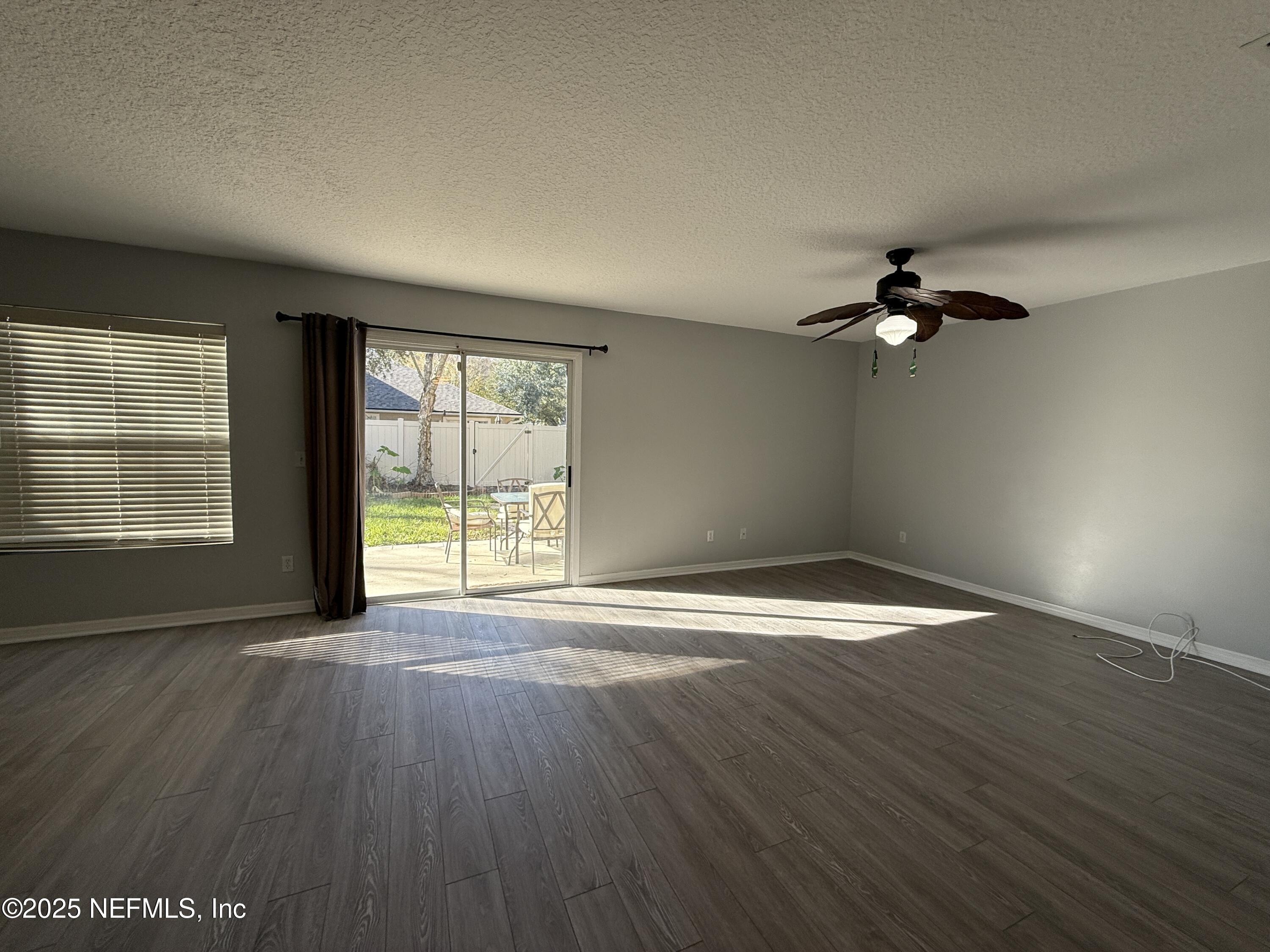 1865 Green Springs Circle, Unit C Fleming Island, FL 32003 - Photo 9 of 29 an empty room with wooden floor fan and windows