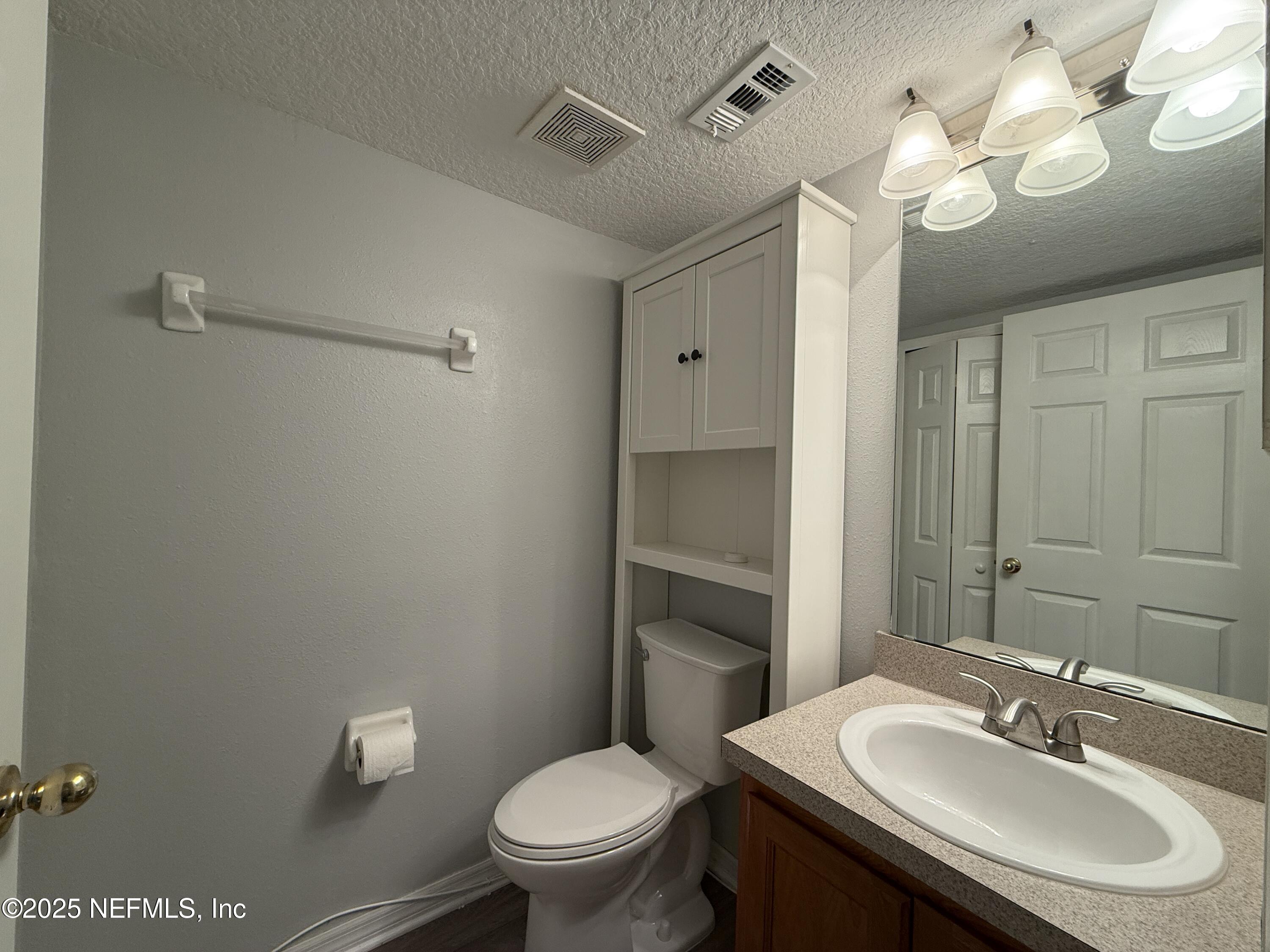 1865 Green Springs Circle, Unit C Fleming Island, FL 32003 - Photo 10 of 29 a bathroom with a sink vanity mirror and toilet