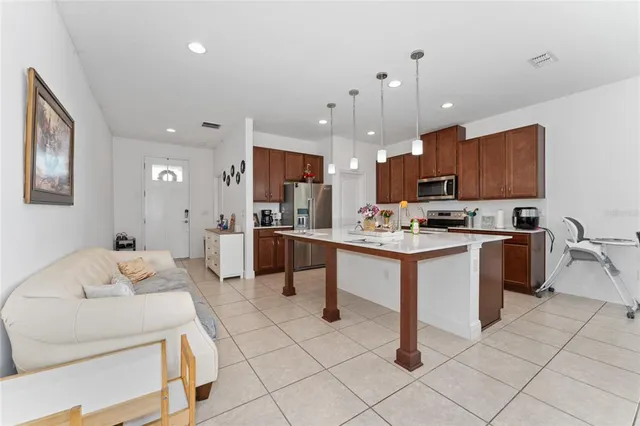 a kitchen with kitchen island granite countertop stainless steel appliances a sink a counter top space cabinets and a window