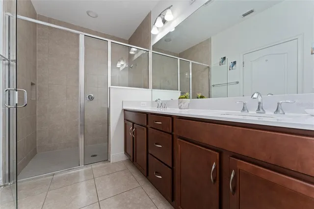 a bathroom with a shower sink vanity and mirror
