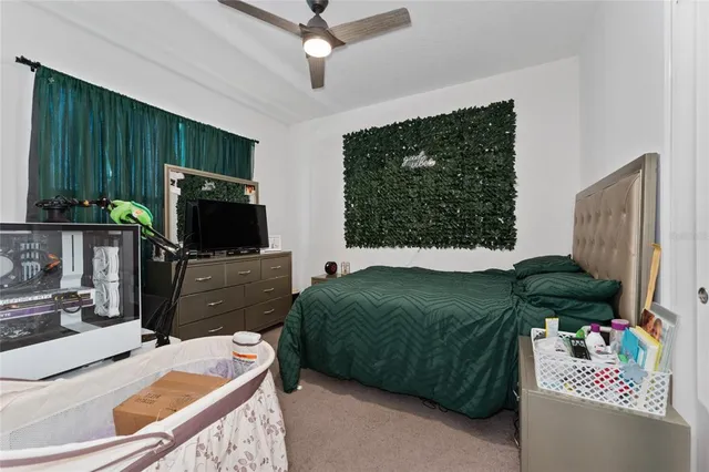 a bedroom with a bed television and a window