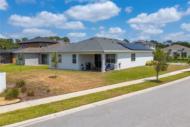 a view of a house with a big yard and large tree