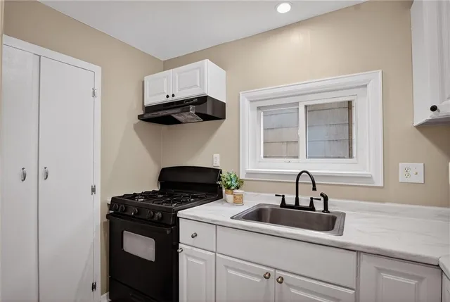 a kitchen with a sink cabinets and window