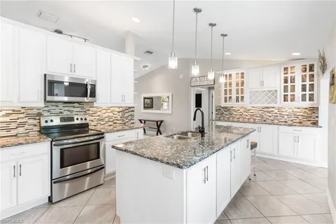 a kitchen with stainless steel appliances granite countertop a sink and a stove