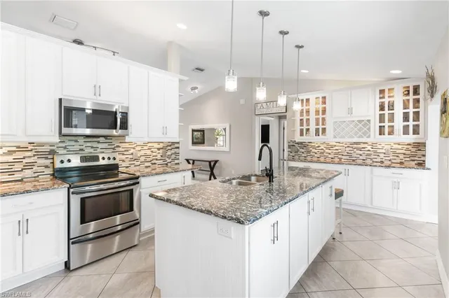 a kitchen with stainless steel appliances granite countertop a sink and a stove